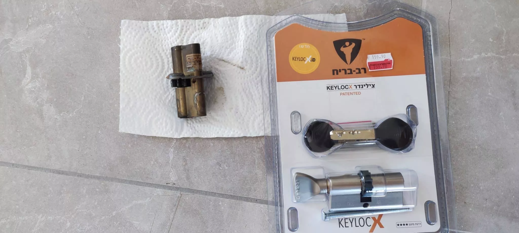 החלפת צילינדר פלדלת לבד | בתמונה רואים צילינדר רב בריח חדש באריזה ולידו מונח צילינדר פלדלת ישן