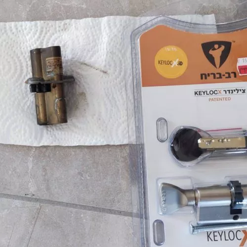 החלפת צילינדר פלדלת לבד החלפת צילינדר פלדלת לבד | בתמונה רואים צילינדר רב בריח חדש באריזה ולידו מונח צילינדר פלדלת ישן